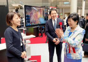 小池百合子知事（右）は表彰式後、アナウトのブースを視察した写真画像