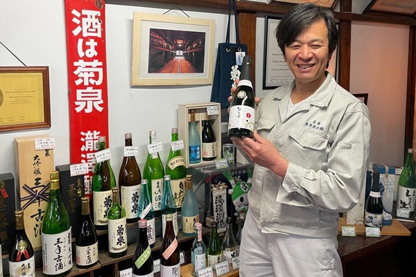 スパークリング純米酒「菊泉　ひとすじ」を手にする滝澤英之氏